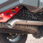Close-up of a vehicle's exhaust system with a red component and 'Torqit' branding.