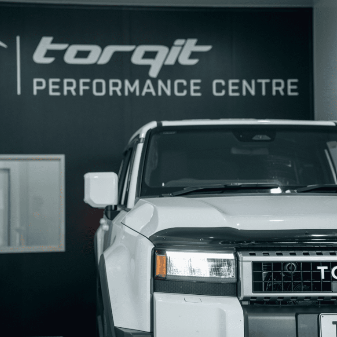 White truck in front of a 'torqit Performance Centre' sign