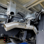 Close-up of a metallic exhaust system with 'torqit' branding on a vehicle.