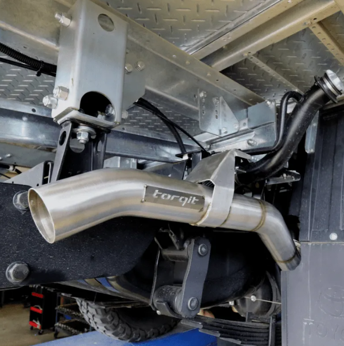 Close-up of a metallic exhaust system with 'torqit' branding on a vehicle.