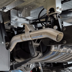 Close-up of a car exhaust system with a brand logo on a metallic background