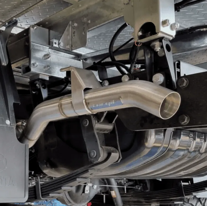 Close-up of a car exhaust system with a brand logo on a metallic background