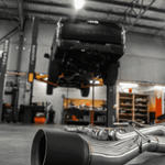 Car exhaust system on a concrete floor in a workshop.