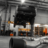 Car exhaust system on a concrete floor in a workshop.