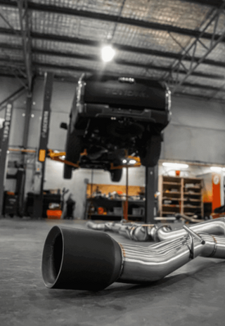 Car exhaust system on a concrete floor in a workshop.