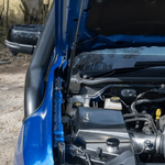 Close-up of a blue vehicle's engine compartment with visible components.