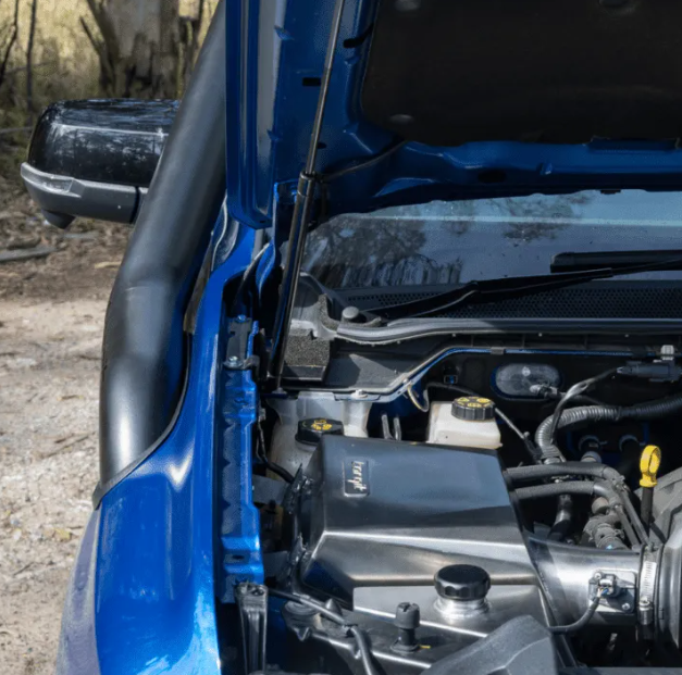 Close-up of a blue vehicle's engine compartment with visible components.