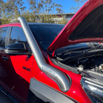 Red car with an open hood and a silver protective grille guard.
