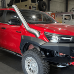 Red truck with off-road accessories in a showroom setting