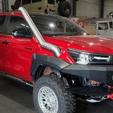 Red truck with off-road accessories in a showroom setting