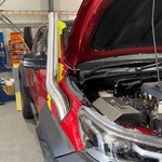 Red truck with open hood in a garage setting