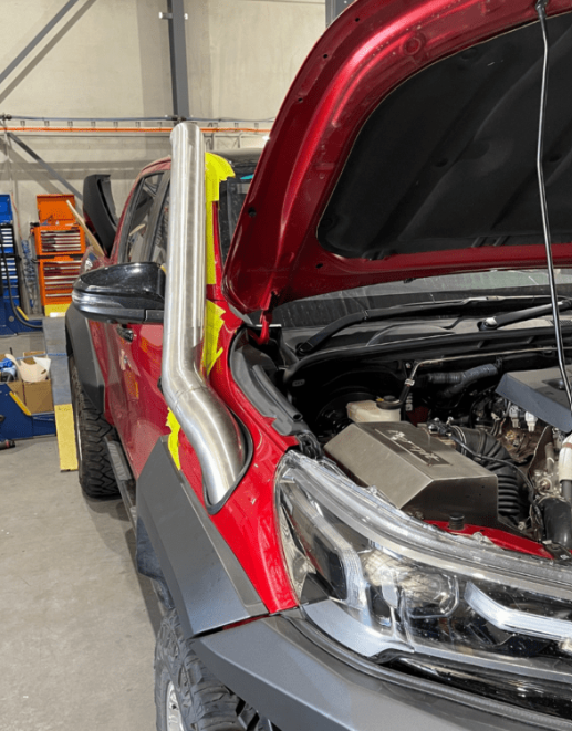 Red truck with open hood in a garage setting