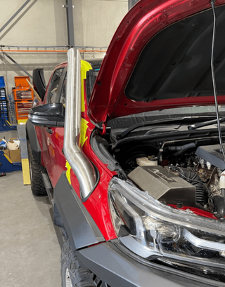 Red truck with open hood in a garage setting