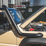 Beige off-road vehicle with a black roll bar in an outdoor setting