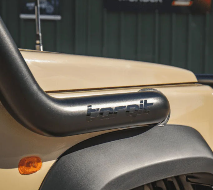 Close-up of a motorcycle exhaust with 'torqit' branding, blurred background