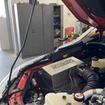 Car with open hood in a garage setting