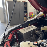 Car with open hood in a garage setting
