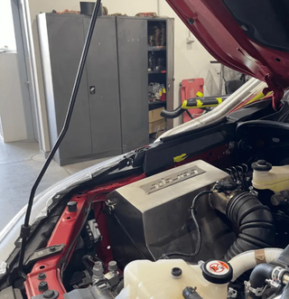 Car with open hood in a garage setting