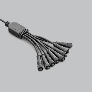 Eight-way splitter loom for the rock light kit, a moulded junction block with one feed lead in and eight sealed screw-lock connectors out, laid on a grey ground