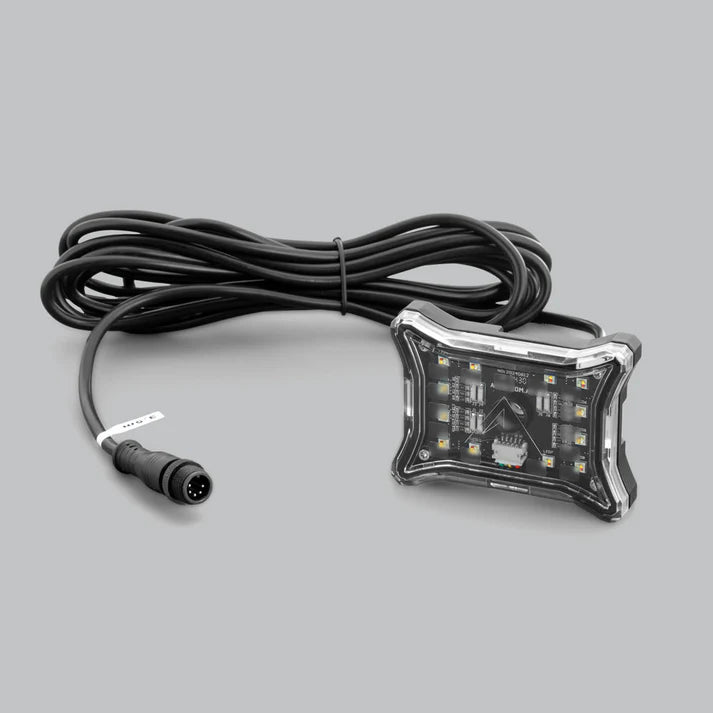 Rock light with its four-pin weatherproof lead coiled behind it, the light lying face up on a grey ground