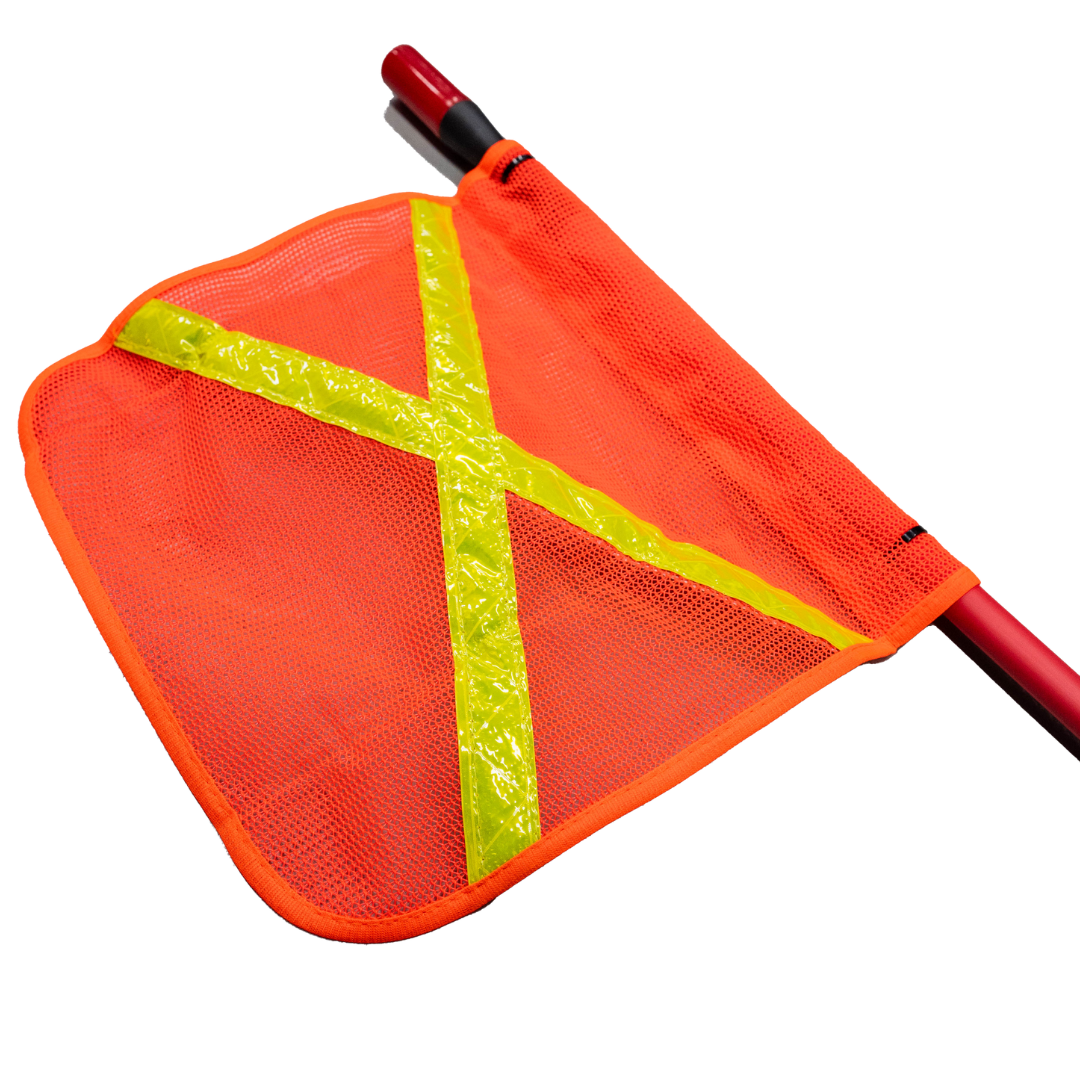 Close-up of the orange mesh safety flag on the whip, yellow reflective tape crossing it diagonally and the red fibreglass shaft threaded through the sleeve