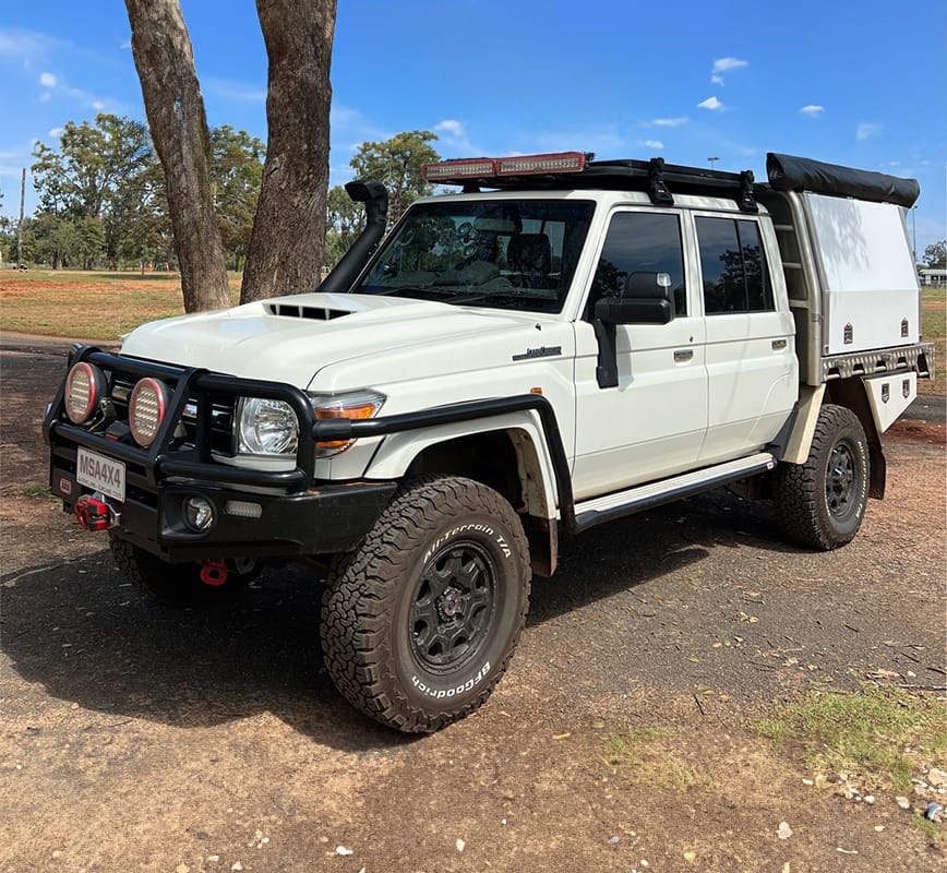 White off-road vehicle with black accents on a dirt road