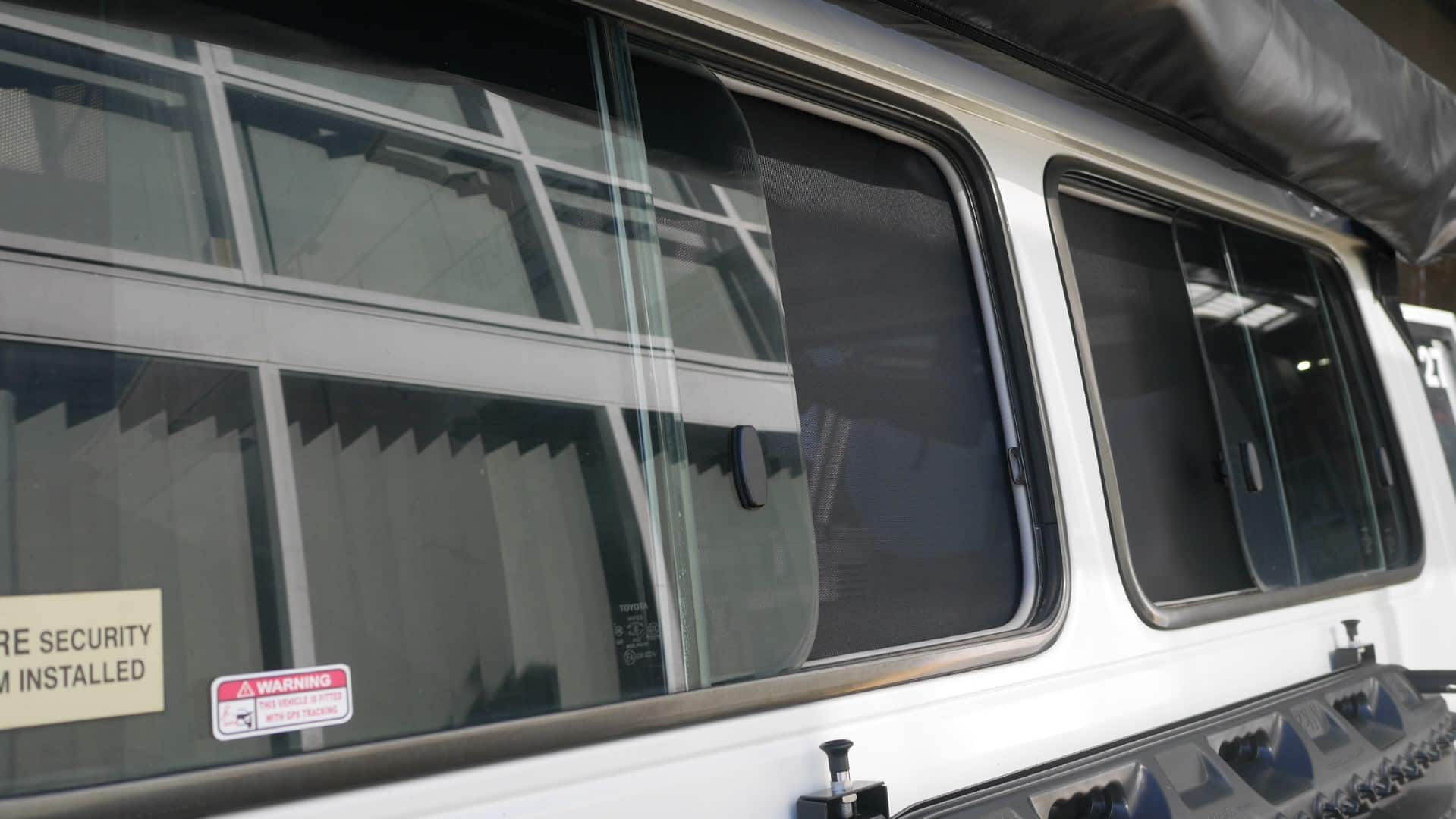 Close-up of a vehicle window with security stickers on a white background
