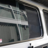 Close-up of a vehicle window with security stickers on a white background