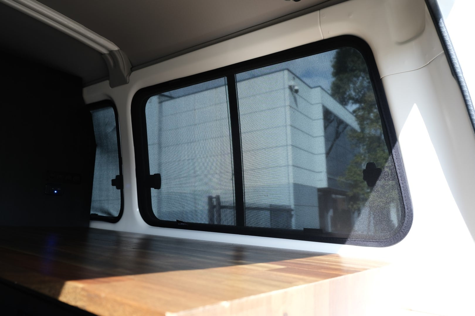 Interior of a vehicle with a large window showing a building outside