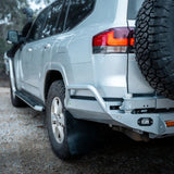 Silver SUV with off-road tire and bumper on a gravel surface