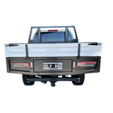 Back view of a truck with a flatbed and license plate on a white background