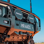Close-up of a vehicle's front bumper with 'ROADVISION' branding and a license plate against a clear blue sky.