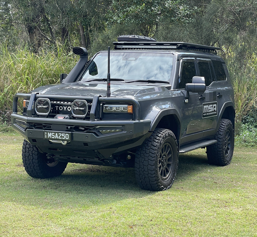 Gray Toyota prado 250 with off-road equipment on a grassy area