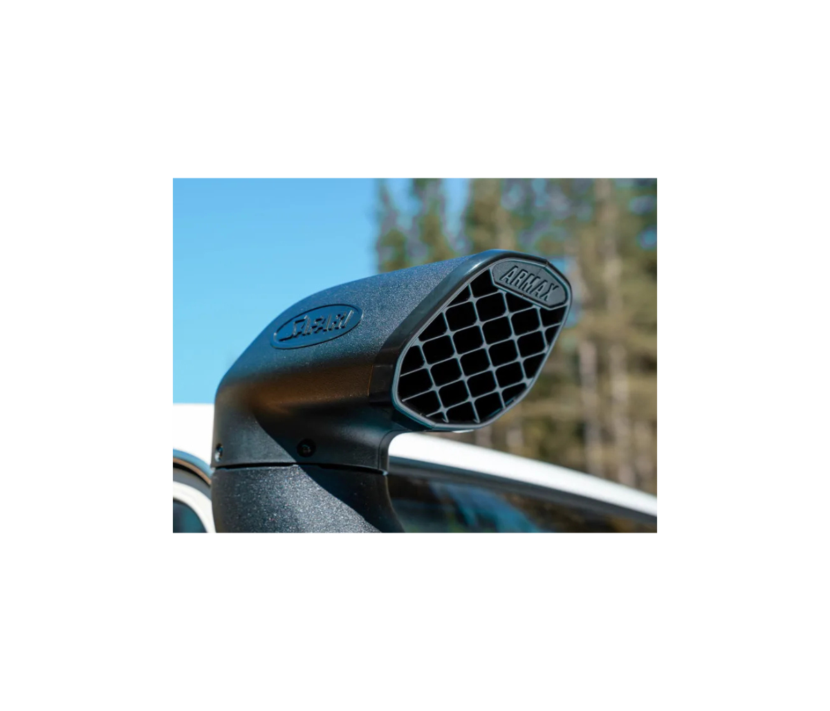 Car exhaust pipe with 'Arden' branding against a blurred outdoor background