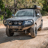 Nissan Patrol SUV on a dirt road with trees in the background