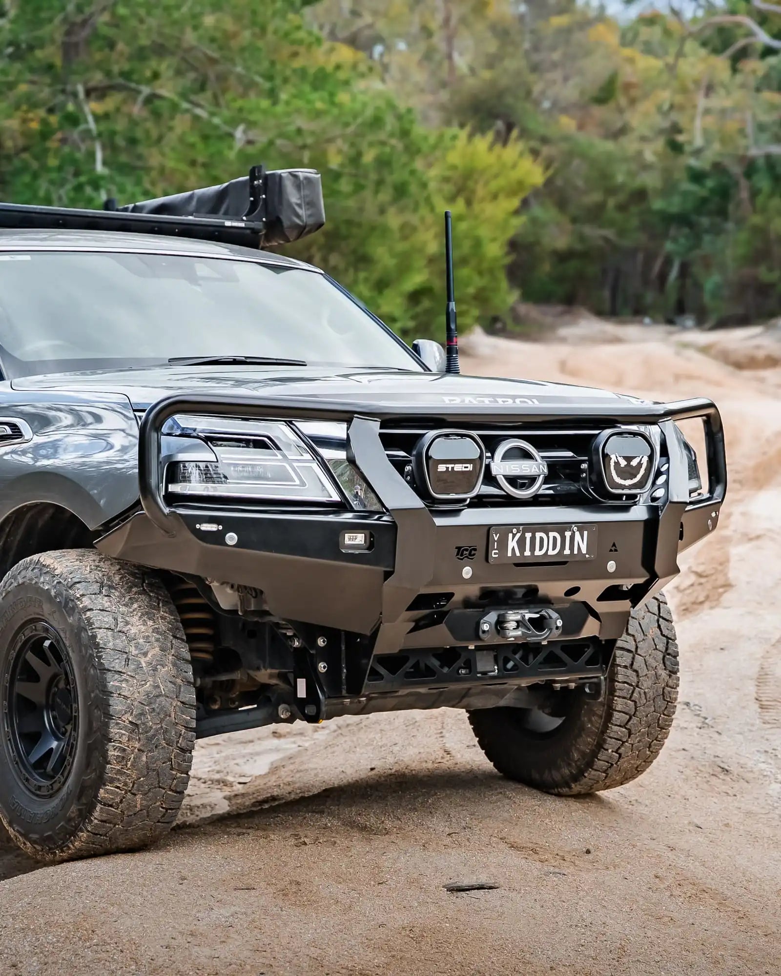 Off-road vehicle on a dirt road with trees in the background