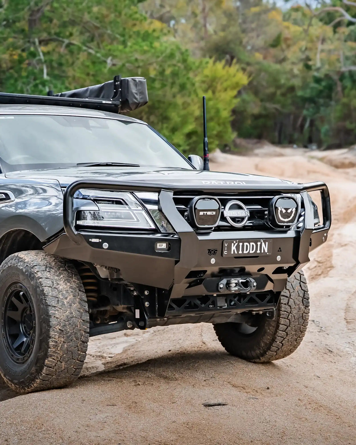 Off-road vehicle on a dirt road with trees in the background