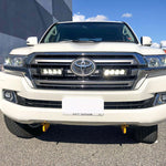 White Toyota 200 series parked on a street with a building in the background with Lazer Lamps Grille Kit – Toyota Land Cruiser 200 Series (2015–2021)