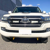 White Toyota 200 series parked on a street with a building in the background with Lazer Lamps Grille Kit – Toyota Land Cruiser 200 Series (2015–2021)