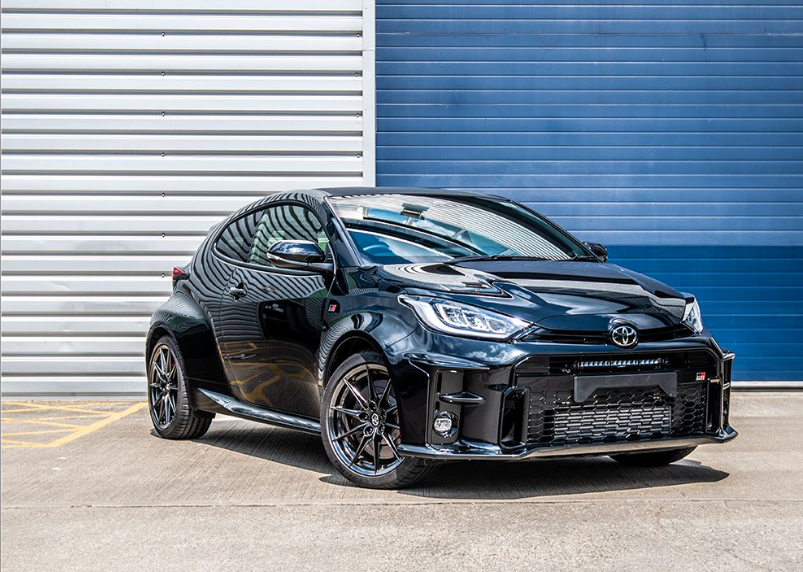 Black Toyota car parked in front of a blue and gray striped wall with Lazer Lamps Bumper Beam Mount Kit for Toyota Yaris GR