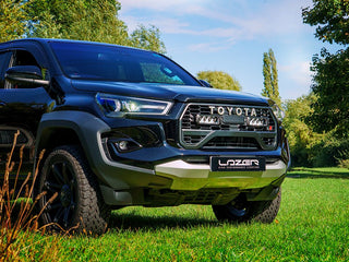 Toyota truck with Lazer branding on a grassy area with trees in the background