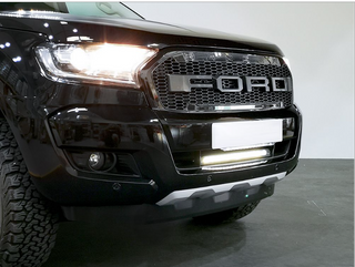 Close-up of a Ford vehicle's front grille and headlight with Lazer Lamps Bumper Beam Mount Kit – Ford Ranger (2016–2022)