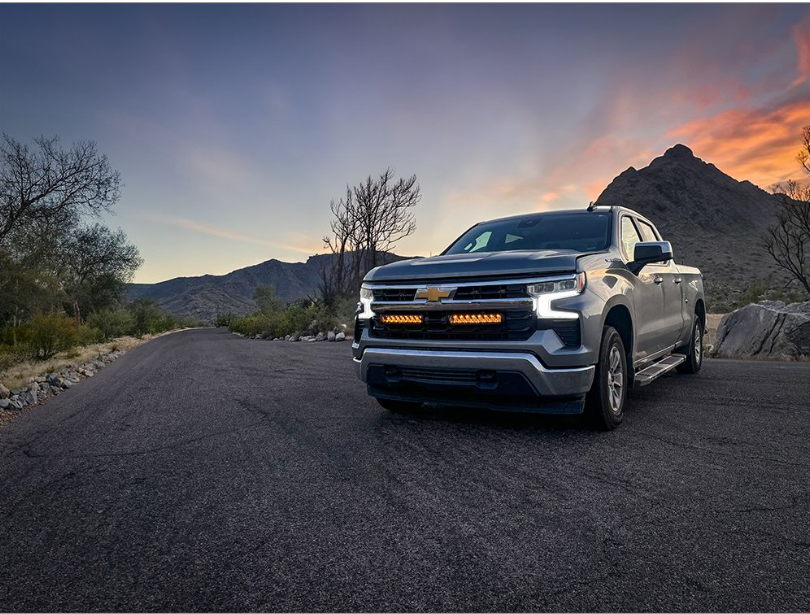 Chevrolet truck on a desert road with mountains in the background