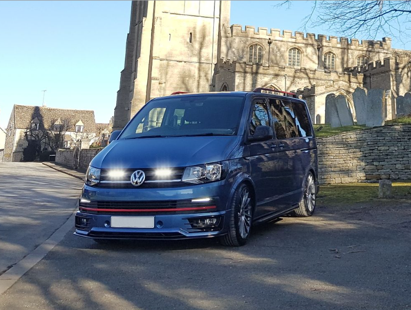 Blue Volkswagen van parked in front of a castle-like building