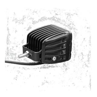 DX4 work light from above and to the side, showing the deeply finned cast heatsink, the stainless mounting bracket and threaded stud, and the lead leaving the rear