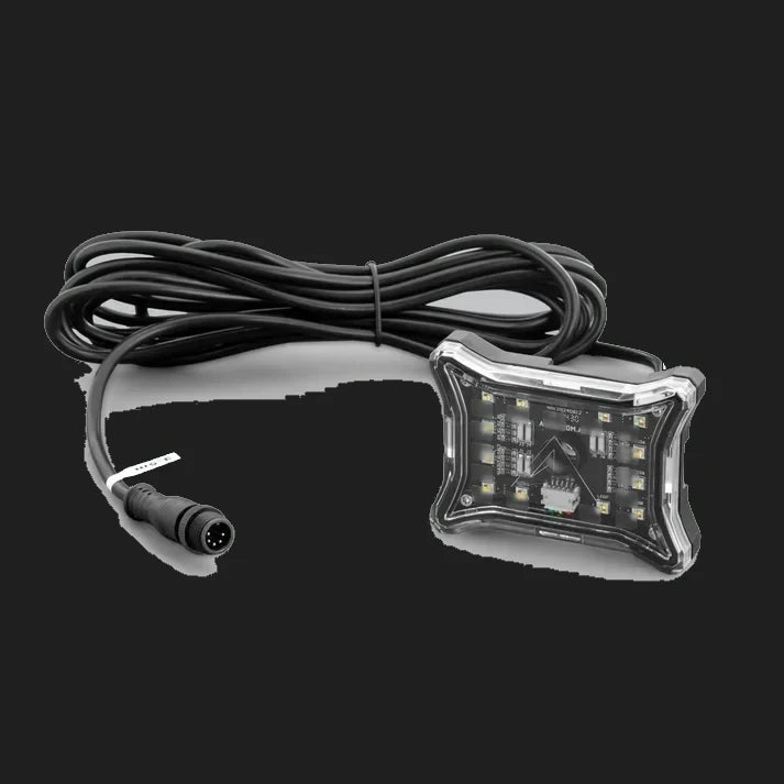 Rock light with its four-pin weatherproof lead coiled behind it, the light lying face up on a grey ground