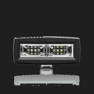 ALTIQ CX4 scene work light square on, a wide rectangular lens holding two reflector segments each with a dense cluster of LEDs, in a black housing with the mounting bracket beneath