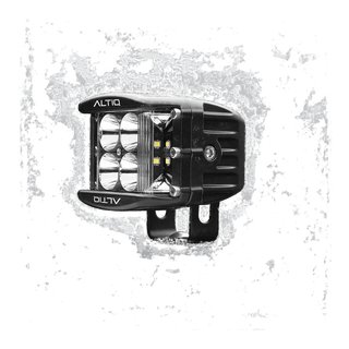 DX4 hybrid work light turned further round, the four spot reflectors and the amber-tinted side flood LEDs both visible with the ALTIQ name on the bezel