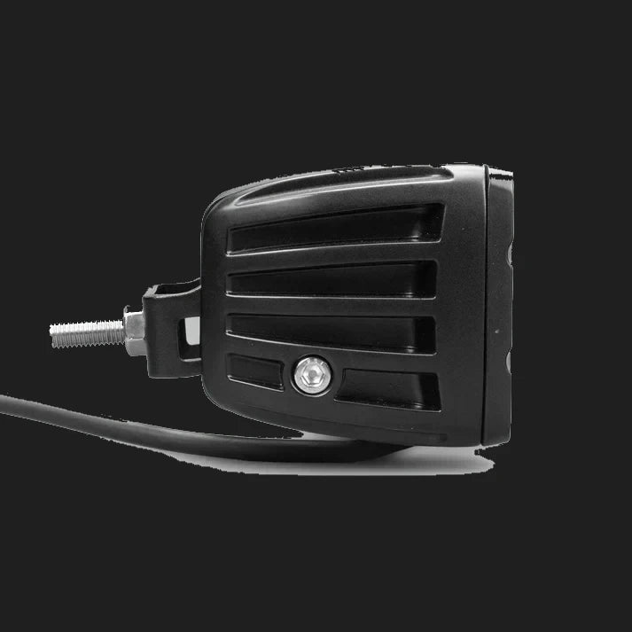 Black DX4 Scene work light side on, the ribbed housing profile with the mounting bracket bolted through the flank and the cable running forward