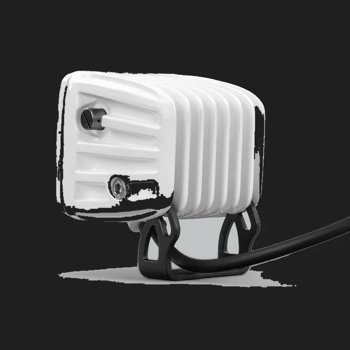 White DX4 Scene work light seen from the side, the ribbed white housing with its adjustment screw and the black mounting bracket with the lead running behind